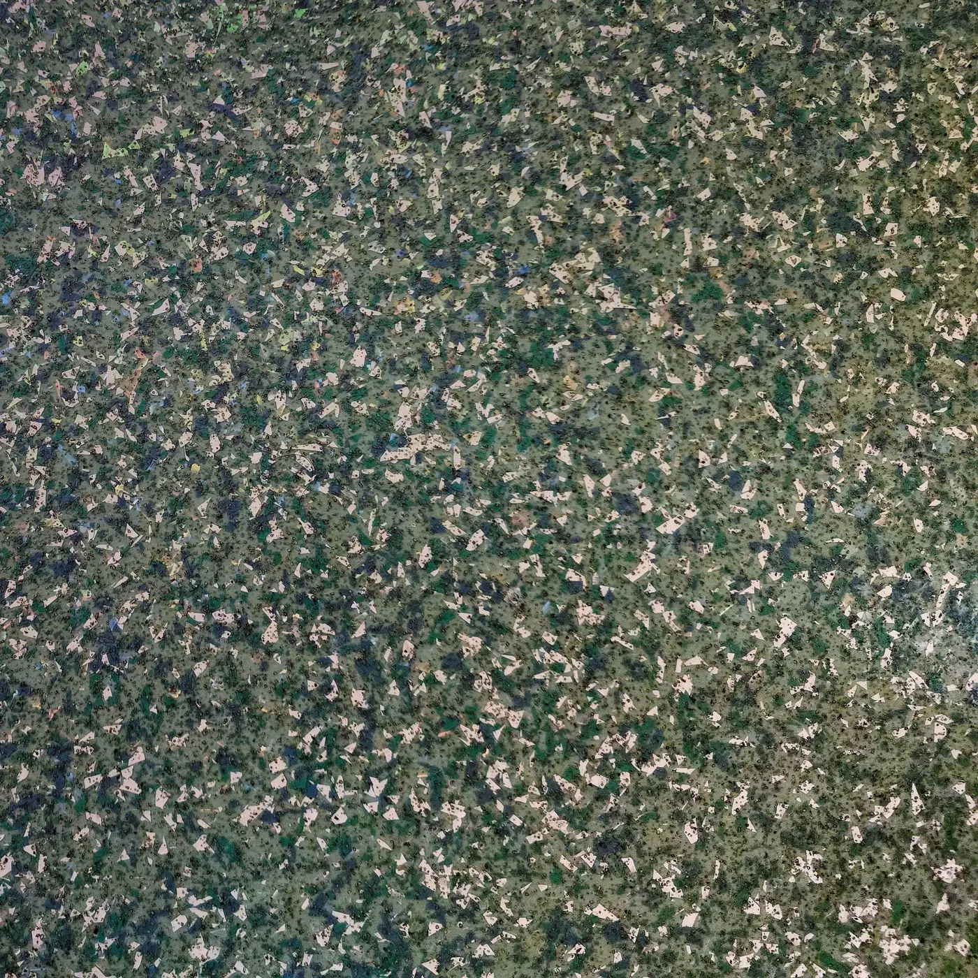 Close-up of a full-broadcast flake floor in green, gray and cream chips.