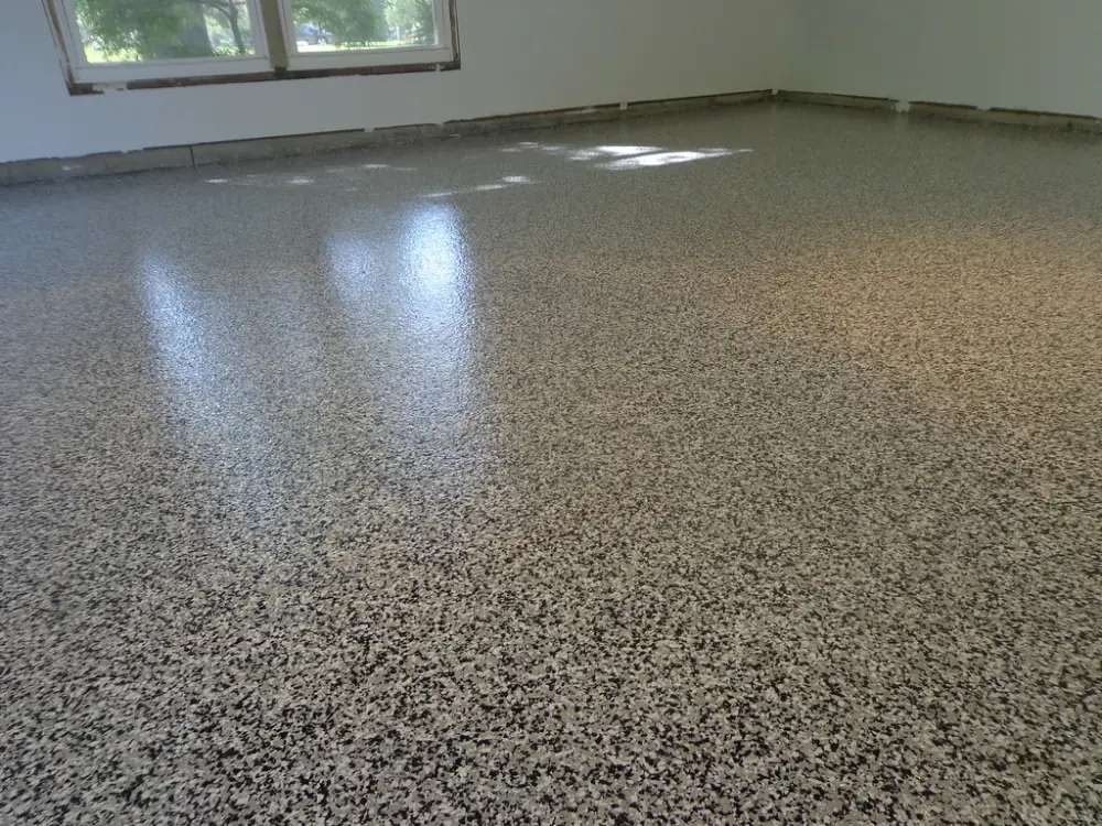 A large garage with a glossy gray, white and black chip floor.