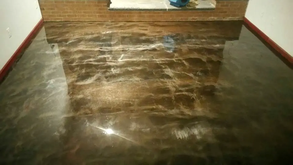 A glossy metallic brown epoxy floor reflecting a brick fireplace.