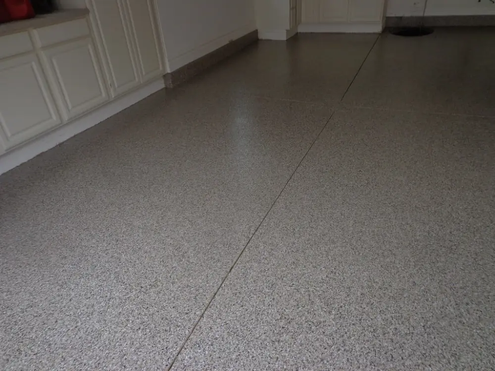 A garage floor with a fine quartz broadcast finish and cut joints.